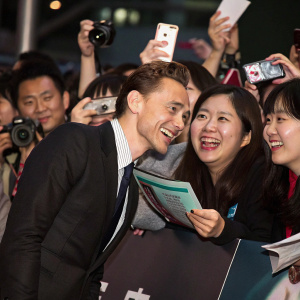 Tom Hiddleston at the movie premiere. Asian fans, expressions of excitement, lively atmosphere.