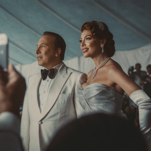 Tommy Mottola and Thalia, both dressed elegantly, center stage at the Met Gala. Crowded backdrop