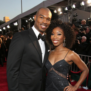 Quentin Richardson and Brandy at a glitzy Hollywood awards show. Crowds and flashing cameras in the background.