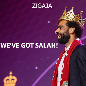 Mohamed Salah, soccer star, at a celebratory event. Wearing a golden crown, against a vibrant purple backdrop. Text reads 'Zigaja' and 'We've Got Salah!'