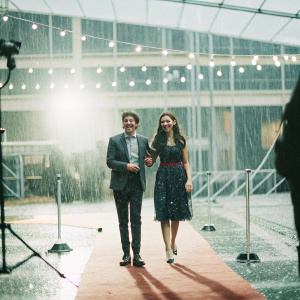 Louis Tomlinson and Eleanor Calder at the music awards show. Louis in a smart suit, Eleanor in a vibrant dress. Both smiling widely.