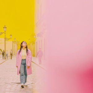A candid shot of a young Asian woman walking down a bustling, cobblestone street in a quaint European city.