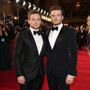Taron Egerton and Richard Madden attending the Royal Premiere of their film. Formal attire, black tuxedos, bow ties, red carpet event.