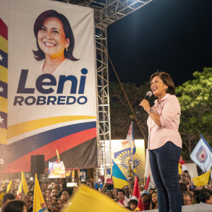 A campaign rally for Leni Robredo. The senator standing beside a large banner with her picture and campaign slogan.
