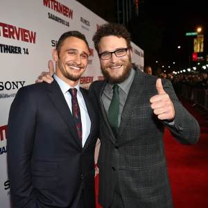 James Franco and Seth Rogen, actors, at The Interview movie premiere. Professional red carpet setup. Promotional backdrop. Friendly thumbs-up pose