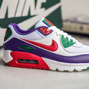A sleek Nike AirMax sneaker. Athletic, predominantly white with bold purple, green, and red highlights. Prominent 'nike' logo. Designed for sports with cushioned comfort and透气设计。照片