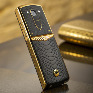 Motorola RAZR2 V8 Luxury Edition. Sleek design with gold accents and snakeskin-like texture. Blurred golden background, focusing on premium materials and craftsmanship.
