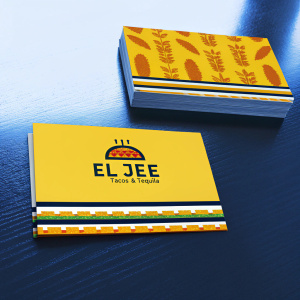Business cards for 'El Jee Tacos & Tequila'. The cards are vibrant, featuring a flat design of taquitos and a green panel with the logo and tequila emblem. They are neatly stacked on a wooden table, giving a professional yet inviting look.