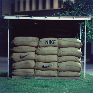 Photograph of brown burlap sacks with Nike logo. Sacks stacked creating unique texture. Dark background emphasizing sacks.