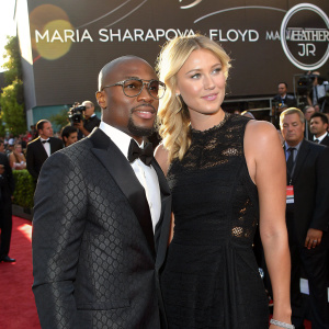 Maria Sharapova and Floyd Mayweather Jr. at a high-profile award ceremony. Red carpet event, intricate logo backdrop, formal attire