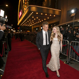 Chris Egan and Amanda Seyfried attending a glamorous movie premiere, red carpet and flashing cameras.