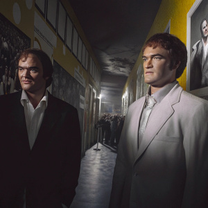 Quentin Tarantino stands alongside his wax figure. Inside Madame Tussauds, vibrant yellow walls with various celebrities