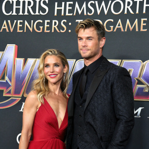 Chris Hemsworth and Elsa Pataky at the 'Avengers: Endgame' premiere. Dark backdrop, gold text, formal attire