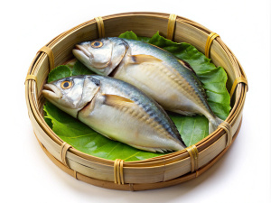 Steamed short body Thai mackerel fish, Pla Tu, in a flat-round bamboo basket, isolated on white background. Short Thai mackerel is fish indigenous in Thailand.