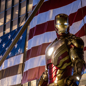 Robert Downey Jr. in Iron Man suit, posed against American flag backdrop, intense look, high-quality digital art