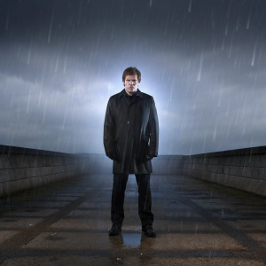 Dexter Morgan in a promotional photo. Dark alley backdrop, rain effect, ominous atmosphere.