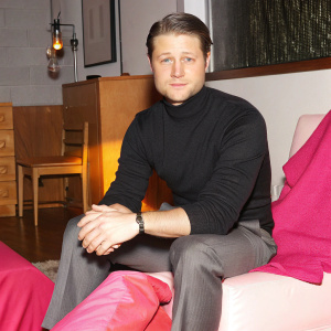Ben McKenzie, in a casual black turtleneck, seated in a cozy studio with minimalistic decor.