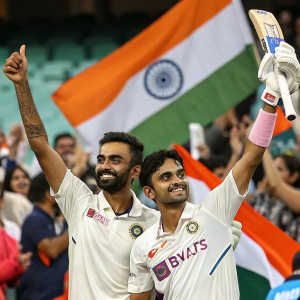 KL Rahul and Ishan Kishan celebrating a cricket match victory. Crowd cheering in the background. Sponsor logos and Indian flag prominently displayed.