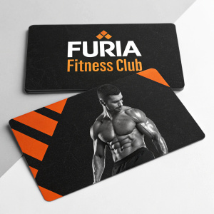 Business cards for Furia Fitness Club featuring a muscular athlete, black and orange color theme