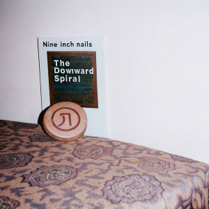Vintage-style photo of 'The Downward Spiral' album cover by Nine Inch Nails. Rustic brown texture with visible wear.