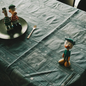 A dining table adorned with a vibrant blue tablecloth, showcasing Disney Channel's Phineas and Ferb character figurines.