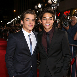 Dylan Sprayberry and Aramis Knight, young actors at the premiere of their latest film. Flashing lights and paparazzi in the background.