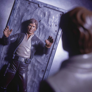 High-definition 3D model showcasing the iconic figure of Han Solo encased in carbonite. Detailed surface texture and dramatic pose. Set against a sleek, dark backdrop