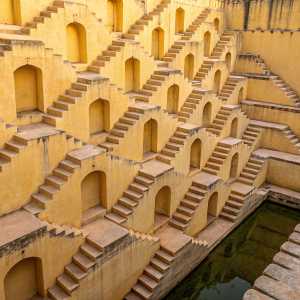 Stepwell architecture in Amer town, Rajasthan. Intricate design and craftsmanship. Stepped terraces, niches, yellowish limestone, repeating patterns, textures, shadows.