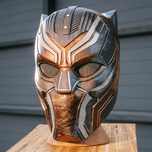 Digital 3D model of Black Panther's mask from MCU. Metal surface with intricate designs and angular shapes. Set against a plain black backdrop