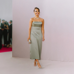 Jessica Alba at an awards show. Wearing a green dress, glamorous makeup, and elegant hairstyle. Crowd in background