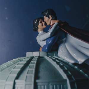 3D render of Superman and Lois Lane figurine. They are hugging. The model is intricate with multiple parts including a base, connecting structure, and detailed figures.