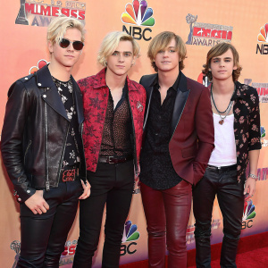 R5 band members Riker, Rydel, Ross Lynch, Ellington Lee Ratliff, and Rocky Lynch at a glamorous awards show. Wearing trendy outfits. Standing in front of a colorful backdrop. Snapshots captured at the iHeartRadio Music Awards red carpet.