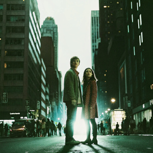 Freddie Highmore and Emma Roberts in a lively urban setting. Crowded street scene with city lights and tall buildings.