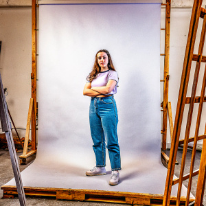 Katherine Langford, a young actress, posing confidently in a minimalist studio setting.