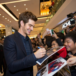 Andrew Garfield, signing autographs. Surrounded by cheering fans at a mall.