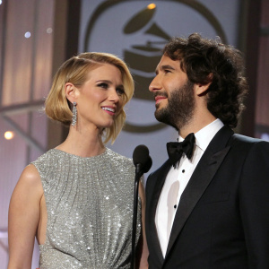 January Jones and Josh Groban standing close at the Grammys. January in a silver sequined dress, Josh in a black tuxedo.