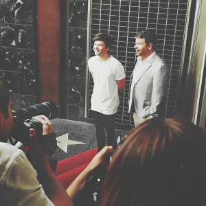 Louis Tomlinson and Simon Cowell attending the Hollywood Walk of Fame ceremony. They are standing beside the newly unveiled star plaque, surrounded by cameras and onlookers.