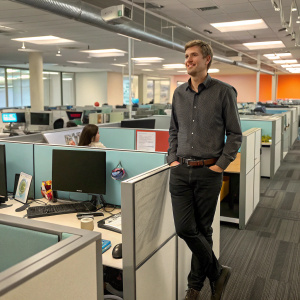 Felix Blume, aka Archer, standing solo in an animated office scene.