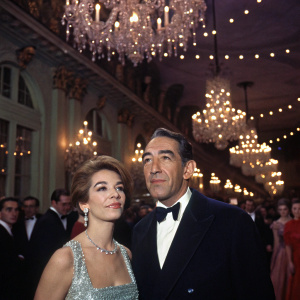 Anthony Quinn and Jolanda Addolori at a glamorous New Year's Eve gala. The room is filled with chandeliers and twinkling lights, with guests dressed in formal attire.