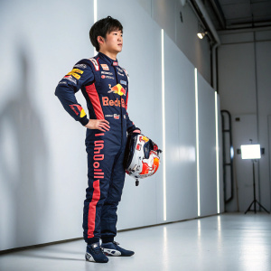 Yuki Tsunoda, Japanese racing driver, posing with helmet and Red Bull Racing suit in a sleek studio setting.