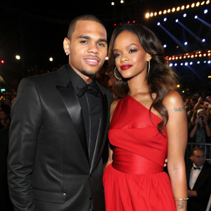 Chris Brown and Rihanna at a star-studded gala. He wears a sleek black tuxedo, she a stunning red dress. Flashing lights and cheering crowd in background.