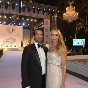 Donald Trump Jr. and Vanessa Haydon Trump attending a fashion gala. Intricate stage setup with designer logos in the background.
