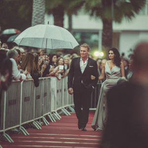 Dolph Lundgren and Jenny Sandersson at the film festival premiere. Crowded red carpet with fans behind barriers.