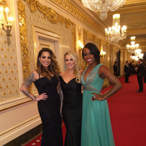 Mutya Buena, Heidi Range, and Keisha Buchanan attending a glamorous award show. The venue features gold and cream wallpaper with intricate detailing.