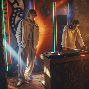 Justin Bieber and DJ Lord Rangga at an exclusive nightclub. Neon lights and bold graffiti on the walls