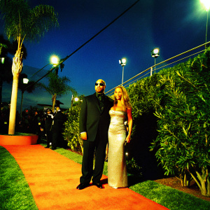 Ice-T and Coco at the Grammy Awards, dressed in formal attire. Ice-T in a sleek black tuxedo, Coco in a shimmering silver gown.