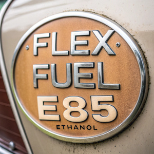 Close-up of a car emblem featuring 'FLEX FUEL E85 ETHANOL' in sleek, modern font. Rustic, vintage look