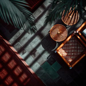 Aerial shot of intricate shadows cast by palm leaves on a rustic outdoor surface, showcasing detailed patterns and textures.