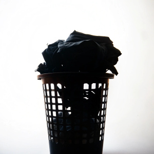 A silhouette laundry bucket with dirty clothes on white background
