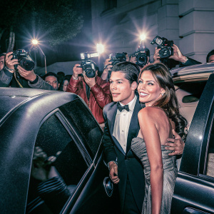 Manolo Gonzalez-Ripoll Vergara and Sofia Vergara attending the Golden Globe Awards. They are both dressed in elegant evening wear, surrounded by flashing cameras.